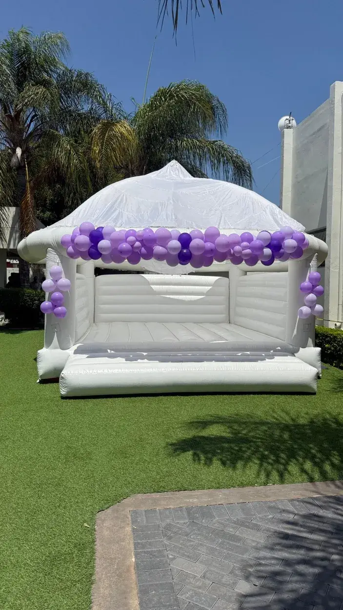 Brincolin Blanco Elegante con globos morados y lavanda en jardín de día