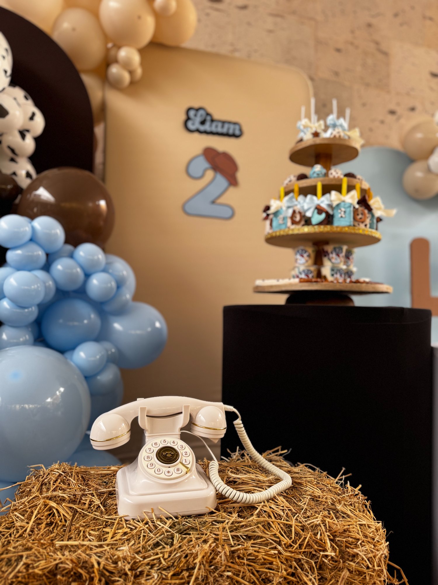 Audio Guest Book con teléfono retro blanco sobre paca de paja en cumpleaños western Liam 2 años